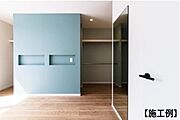 【同社施工例】淡いブルーのアクセントウォールが空間を引き締めます。壁面の埋め込みスペースはディスプレイにも便利です。木目の床が温かみを感じさせ広々とした印象の一室です。