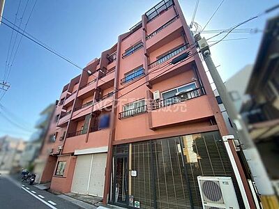 外観：シンプルなデザインが特徴の外観です。道沿いに面していてアクセスしやすい点も魅力です。複数のバルコニーがあり開放感も感じられます。エアコンの室外機が設置されています。街並みによく調和した建物です。