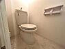 浴室：清潔感のあるシンプルなトイレ空間です。壁や床は明るい色合いで統一され清掃のしやすさも魅力的です。ペーパーホルダーも設置され使い勝手に配慮されています。