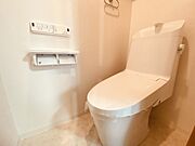 ウォシュレット機能付きのトイレ。収納もあり実用性も兼ね備えた造り。 