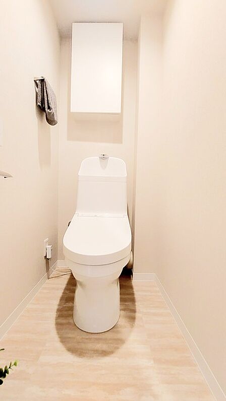 ウォシュレット機能付きのトイレ。収納もあり実用性も兼ね備えた造り。 