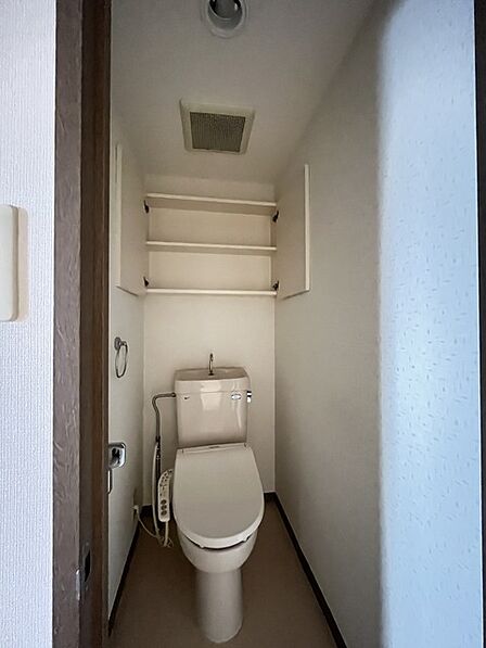 ウォシュレット機能付きのトイレ。収納もあり実用性も兼ね備えた造り。