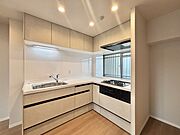 壁付のキッチンは上部に収納が作りやすいのがメリット。空間を有効活用したすっきりとしたデザイン。 