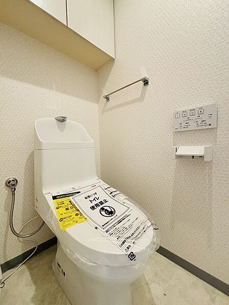 ウォシュレット機能付きのトイレ。収納もあり実用性も兼ね備えた造り。