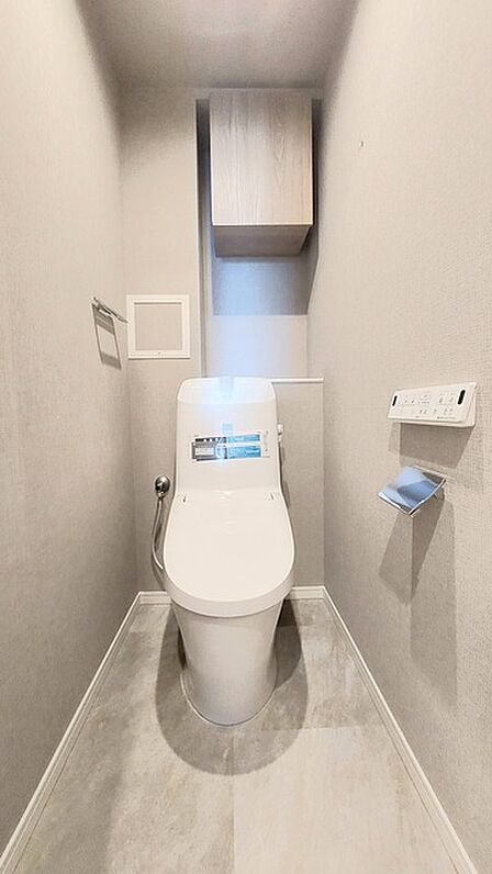 ウォシュレット機能付きのトイレ。収納もあり実用性も兼ね備えた造り。 