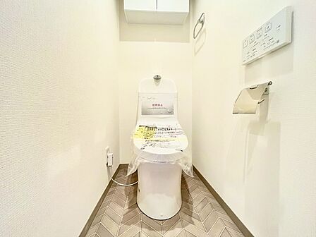 ウォシュレット機能付きのトイレ。収納もあり実用性も兼ね備えた造り。 