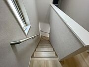 手すりが備え付けられた階段は、シンプルで清潔感のある空間が広がり、日々の暮らしに安心感と落ち着きをもたらす穏やかな設計となっています 