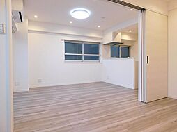 [居間] 【施工例／LDK】LDKに隣接する洋室(約4.8帖)の扉を開放して、一体利用が可能です。合わせると約14.8帖の広々とした空間に◎ 