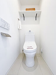 [トイレ] トイレはホワイトを基調とし、明るく清潔感のある空間になっています。温水洗浄便座付きで機能性も◎ペーパーホルダーと、タオルかけのブラックが良いアクセントになっています。